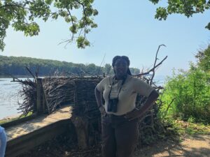 Ranger Jazmyn Bernard stands in front of a human-made example of a Bald Eagle Nest at the Detroit River International Wildlife Refuge on Day One of the SEMIS Coalition's Summer Institute 2023.