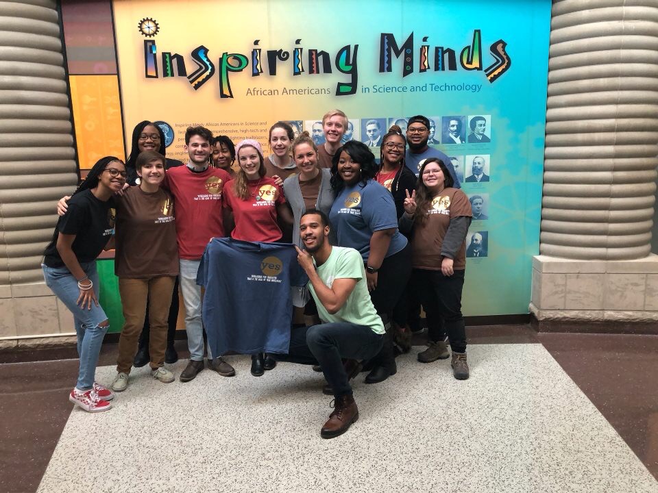 Youth Energy Squad AmeriCorps team at a MLK Day Event at the Charles H. Wright Museum of African American History in Detroit. The background behind them says "inspiring minds" "African Americans in Science and Technology"