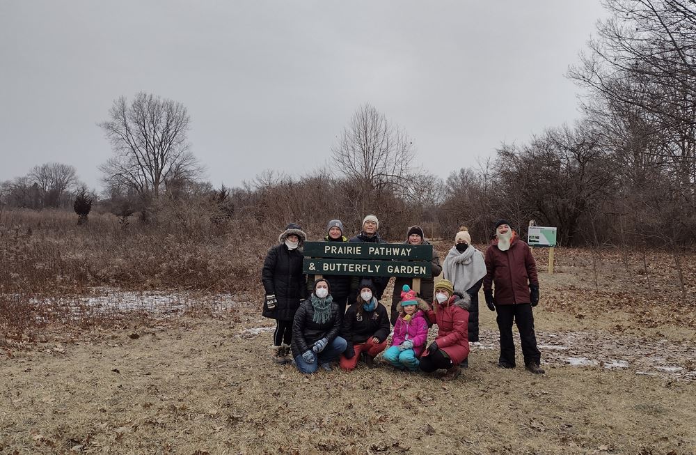 SEMIS Members gather around a sign at Rouge Park in Detroit.